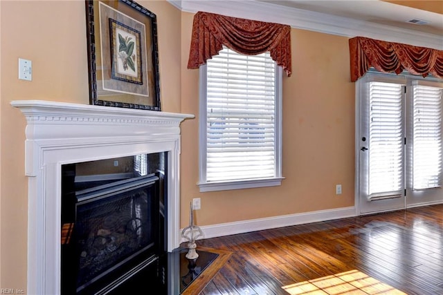 unfurnished living room featuring ornamental molding, a fireplace with flush hearth, and a healthy amount of sunlight