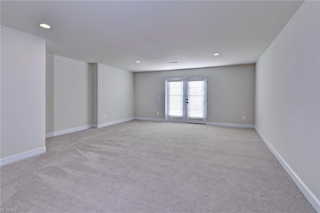 empty room with light carpet, baseboards, and recessed lighting