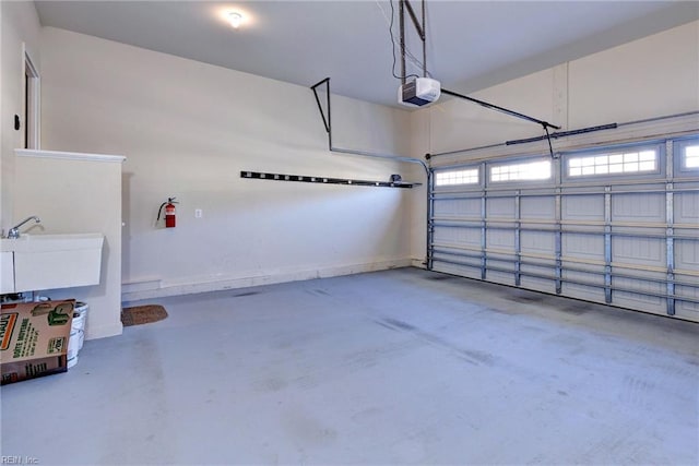 garage with a garage door opener and a sink