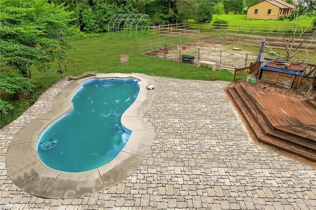 outdoor pool featuring a garden, fence, and a yard