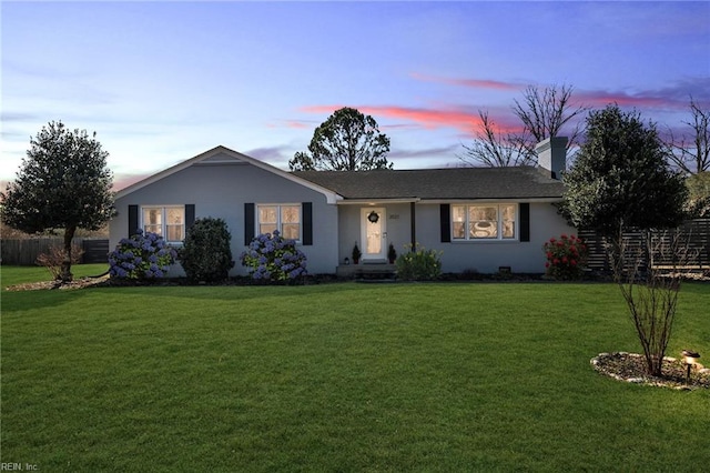 ranch-style house with a chimney, fence, a front lawn, and stucco siding