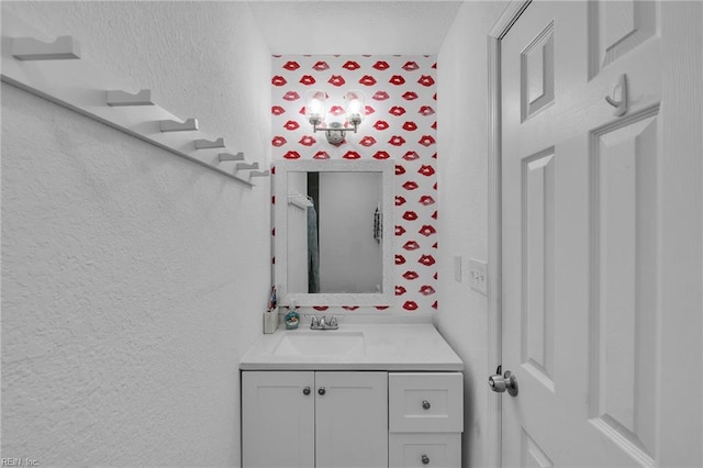 bathroom featuring a textured wall and vanity