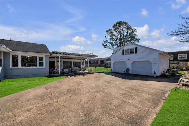 view of front of home with a garage, driveway, an outdoor structure, a front lawn, and brick siding