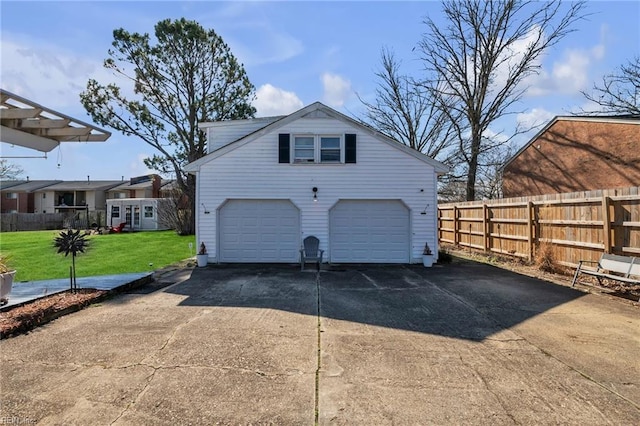 garage featuring driveway and fence