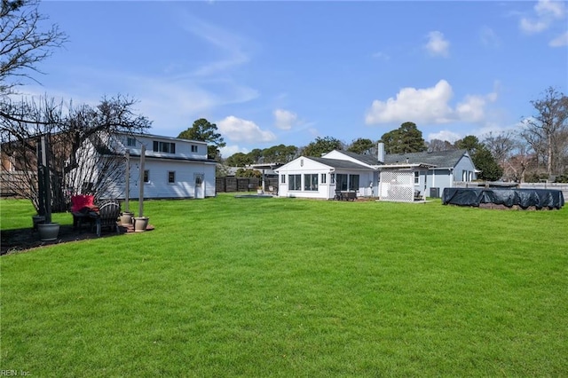 rear view of property with a yard and fence