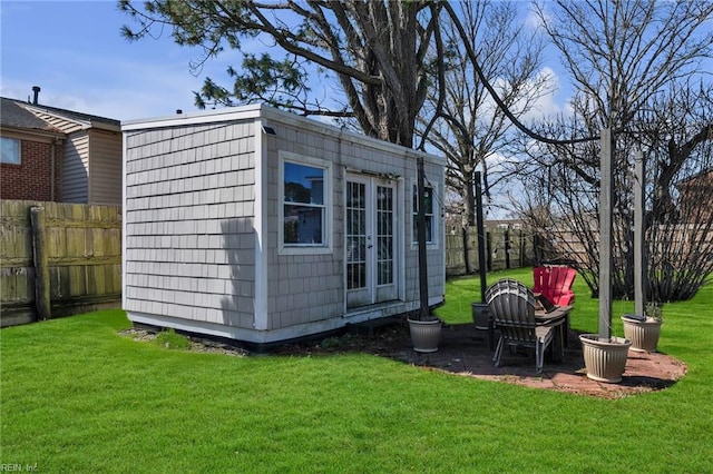 view of outbuilding with a fenced backyard and an outbuilding