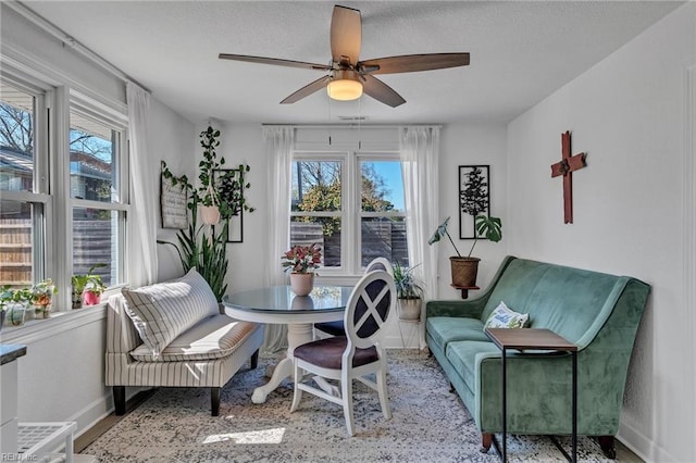 dining space featuring plenty of natural light, baseboards, and a ceiling fan