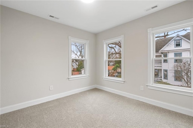 unfurnished room with baseboards, visible vents, and carpet flooring