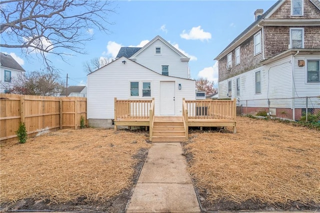 rear view of house featuring a fenced backyard and a deck