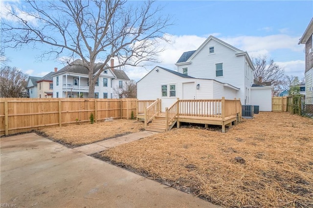 rear view of property with a residential view, a fenced backyard, and a deck