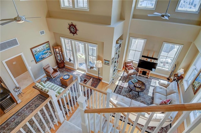 foyer with a towering ceiling, ceiling fan, and wood finished floors