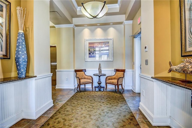 interior space featuring a wainscoted wall, tile patterned flooring, ornamental molding, and a tray ceiling