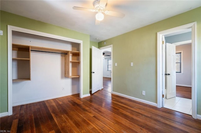 unfurnished bedroom featuring hardwood / wood-style floors, a closet, and baseboards