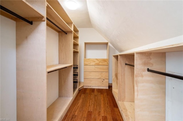 walk in closet with lofted ceiling and dark wood-style flooring