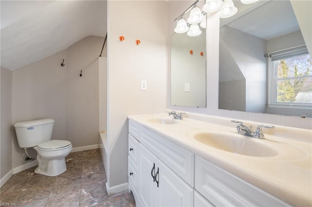 bathroom featuring baseboards, a sink, toilet, and double vanity