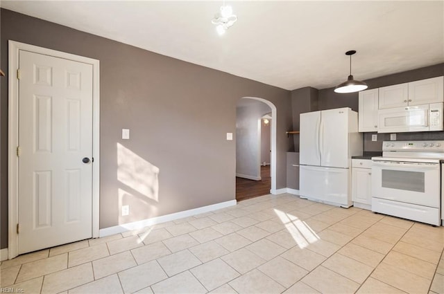 kitchen featuring arched walkways, white appliances, light tile patterned flooring, and white cabinetry