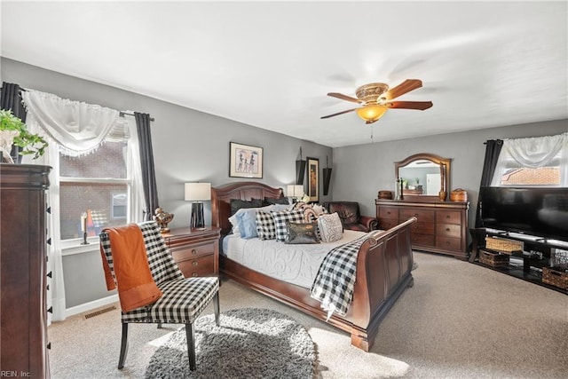 bedroom featuring baseboards, visible vents, ceiling fan, and light colored carpet