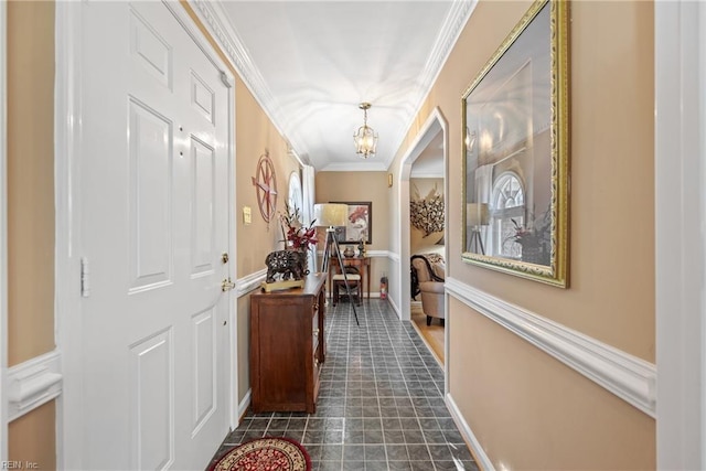 corridor with crown molding and an inviting chandelier