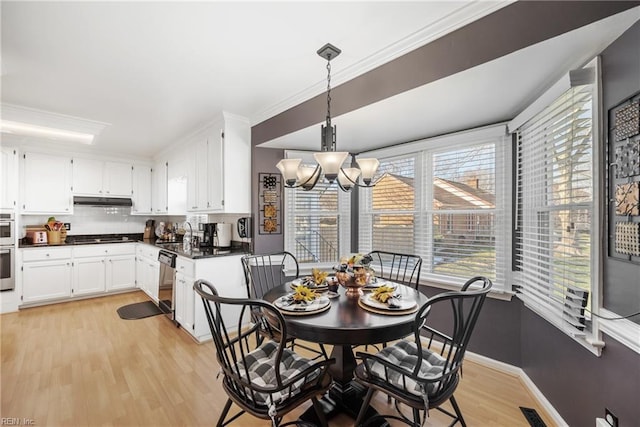 dining area with a notable chandelier, visible vents, light wood-style flooring, ornamental molding, and baseboards