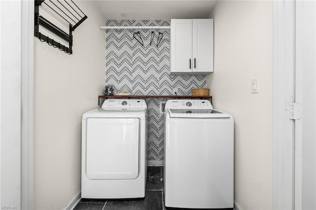 laundry area with baseboards, cabinet space, and washing machine and clothes dryer