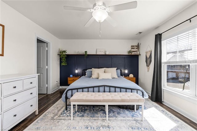 bedroom with ceiling fan, baseboards, visible vents, and dark wood finished floors