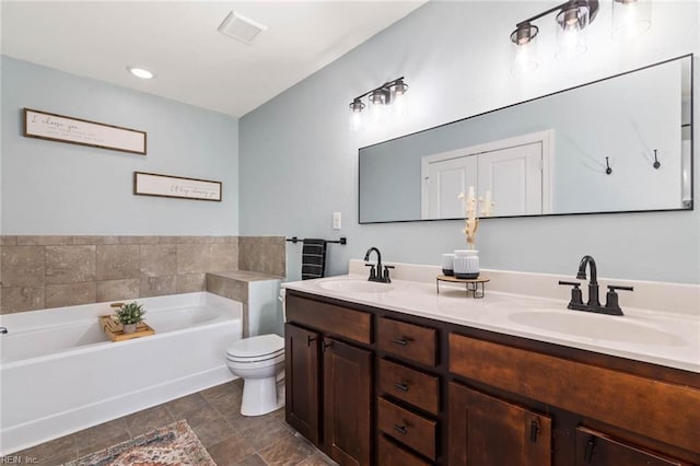 full bathroom featuring double vanity, a sink, toilet, and a bath