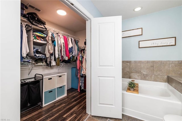 full bathroom featuring visible vents, wood finished floors, a garden tub, a spacious closet, and recessed lighting