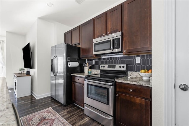 kitchen with dark brown cabinetry, stainless steel appliances, dark wood-type flooring, baseboards, and decorative backsplash