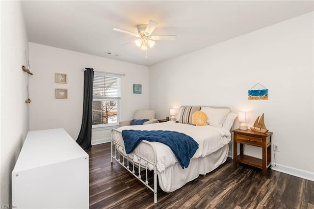 bedroom with ceiling fan, wood finished floors, visible vents, and baseboards