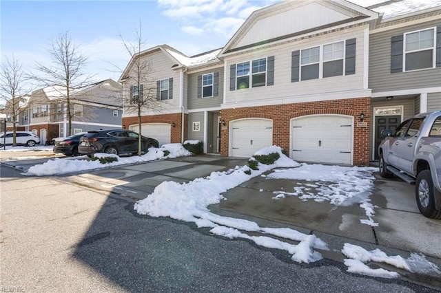 view of front of property with a garage, driveway, and brick siding