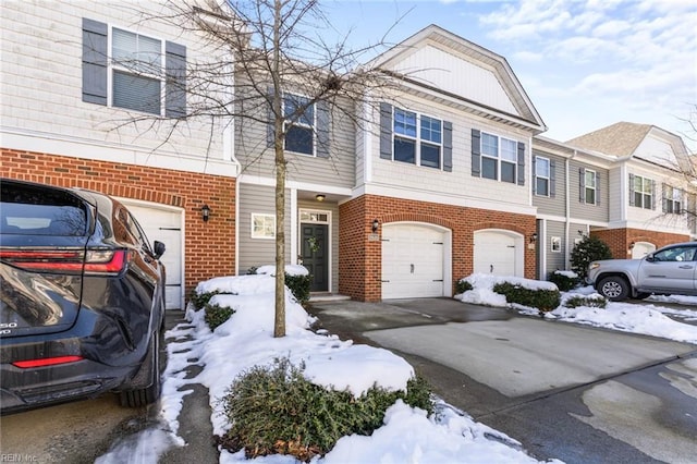 multi unit property featuring concrete driveway, brick siding, and an attached garage