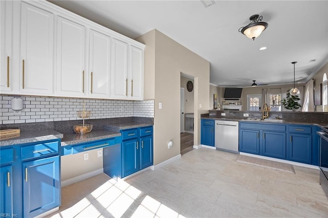 kitchen with appliances with stainless steel finishes, decorative backsplash, a sink, and blue cabinets