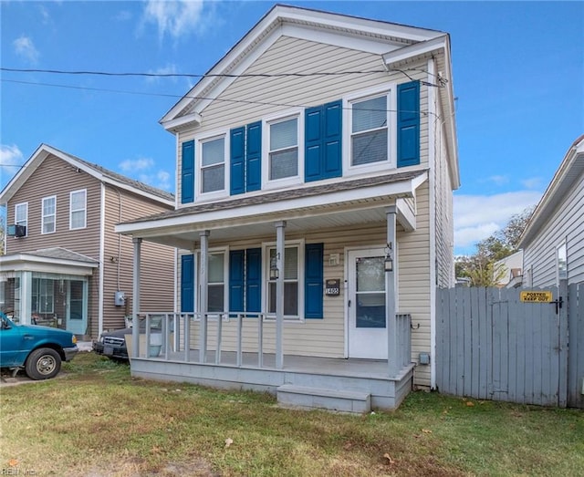 view of front of house featuring covered porch, fence, and a front lawn