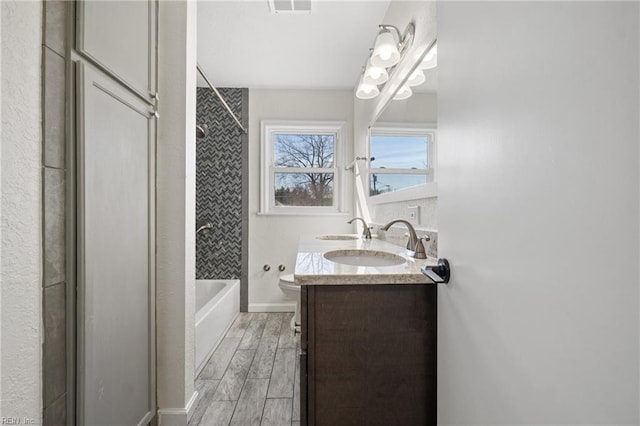 full bath with toilet, visible vents, bathing tub / shower combination, vanity, and wood tiled floor