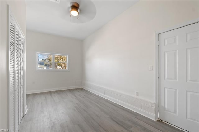 unfurnished bedroom with a ceiling fan, baseboards, and wood finished floors