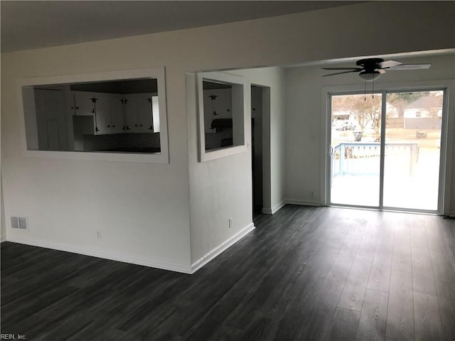 spare room featuring ceiling fan, dark wood-style flooring, visible vents, and baseboards