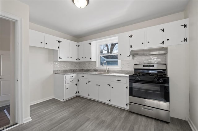 kitchen with under cabinet range hood, a sink, white cabinetry, stainless steel gas range, and light wood finished floors