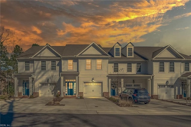 view of property with brick siding, driveway, and an attached garage