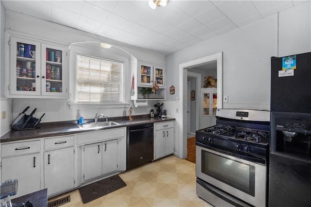 kitchen with black appliances, dark countertops, visible vents, and white cabinets