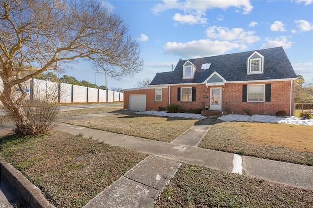 cape cod home featuring a garage, a shingled roof, fence, a front lawn, and brick siding