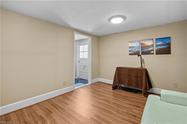 sitting room with baseboards and wood finished floors