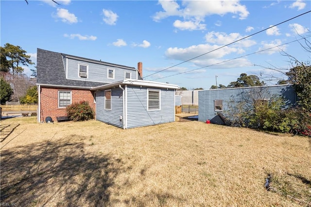 back of property with brick siding, a lawn, and roof with shingles