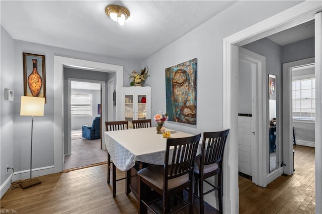 dining space featuring dark wood-style flooring and baseboards