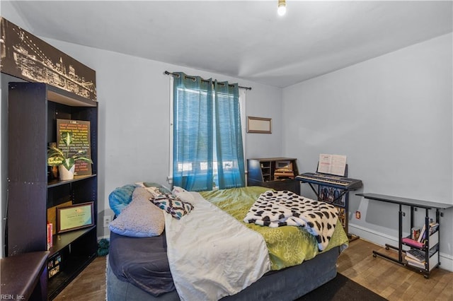 bedroom with baseboards and wood finished floors