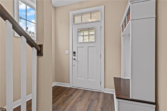 foyer featuring dark wood-type flooring, stairway, and baseboards