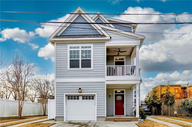 view of front of house featuring an attached garage, a ceiling fan, fence, a balcony, and driveway