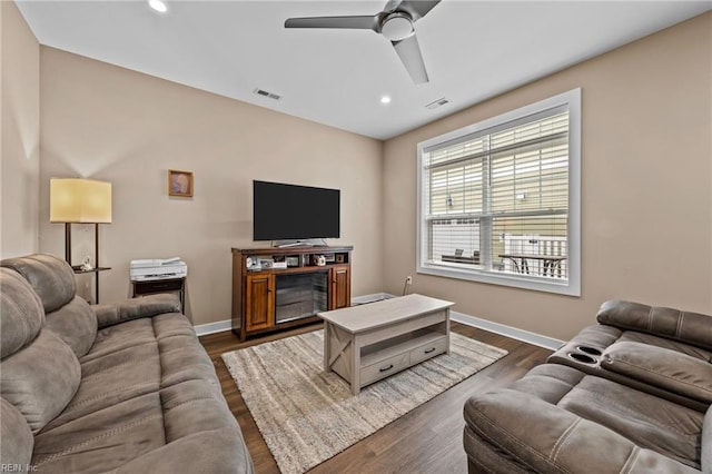 living area with baseboards, visible vents, and dark wood-style flooring