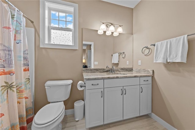 bathroom with curtained shower, baseboards, vanity, and toilet