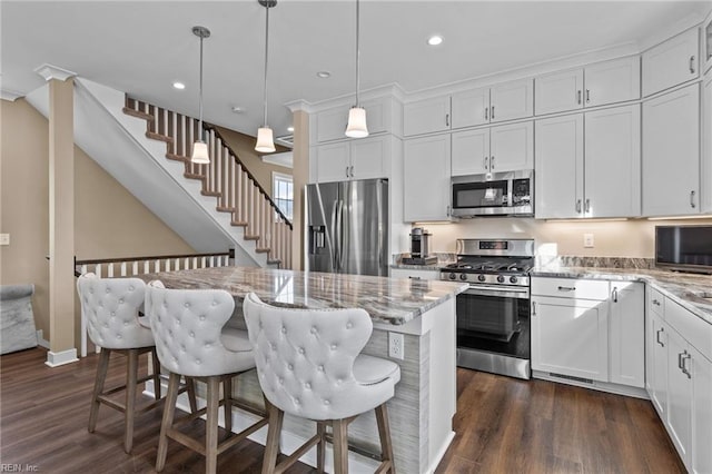 kitchen featuring appliances with stainless steel finishes, dark wood-style flooring, white cabinetry, and light stone countertops