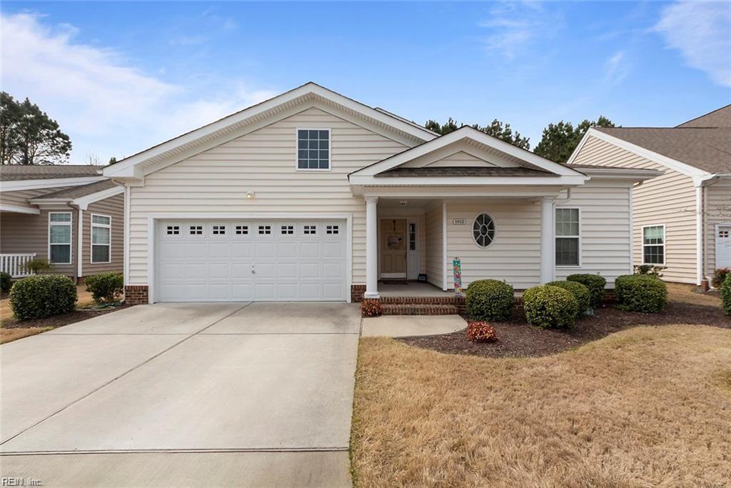 view of front facade featuring driveway, an attached garage, and a front yard